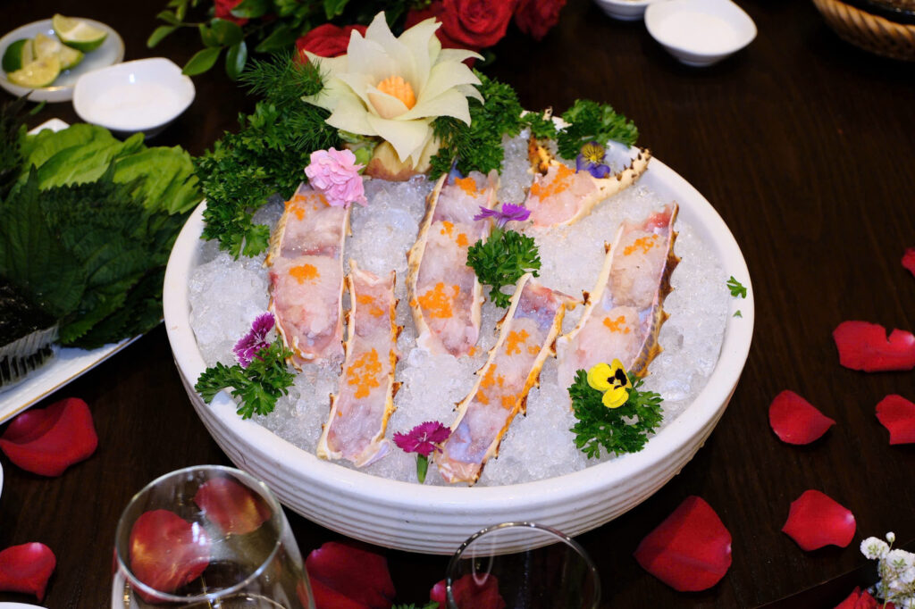 Sashimi càng cua hoàng đế tươi ngon được trình bày trên đá lạnh tại Califood Restaurant & Wine, kết hợp cùng rau thơm và trang trí tinh tế, mang đến trải nghiệm ẩm thực cao cấp và độc đáo cho thực khách